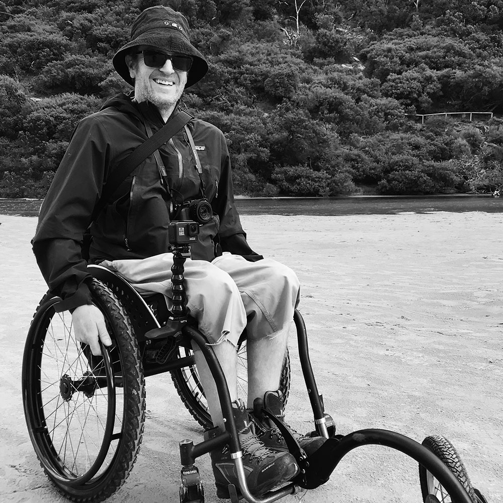 Ryan at a park with outdoor gear on and off-road wheelchair tyres